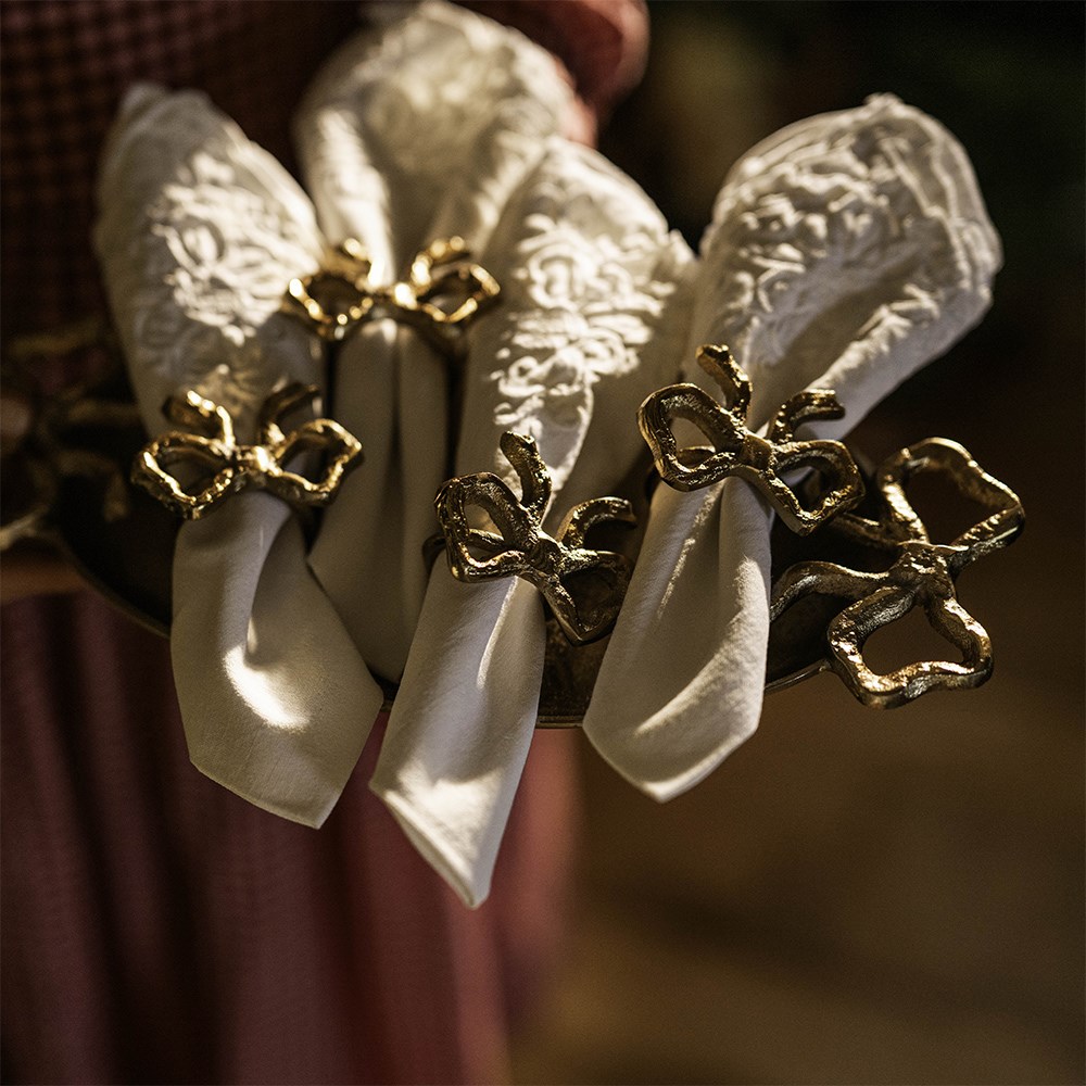 Four gold bow napkin rings