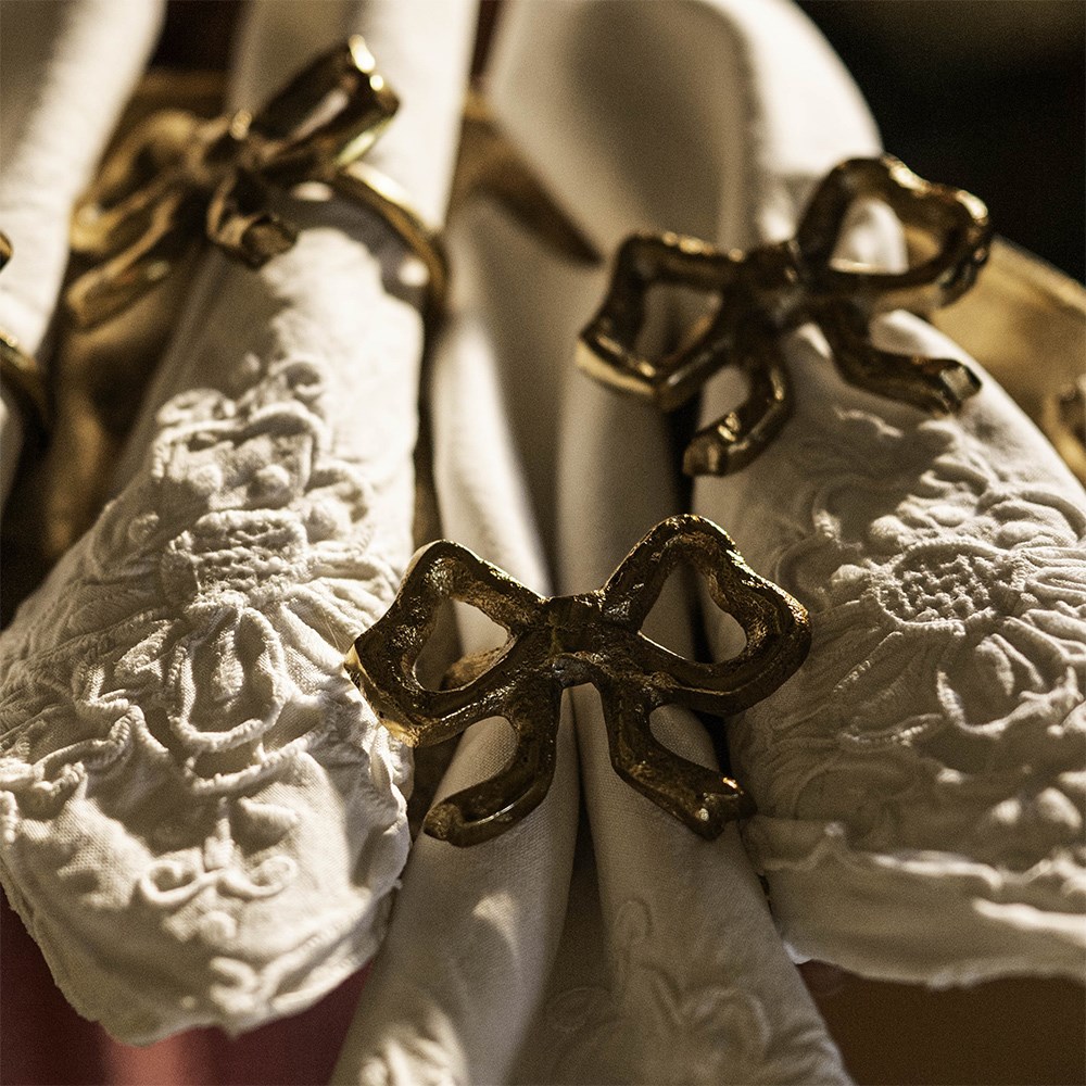 Four gold bow napkin rings